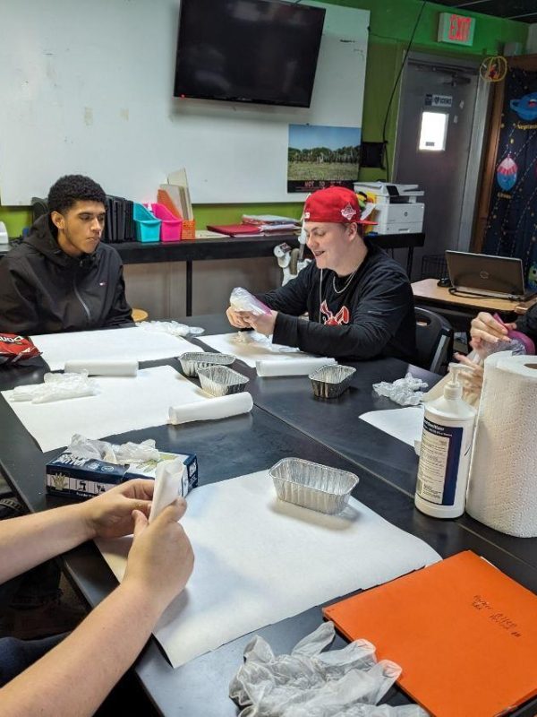 5 students conducting science experiments sitting around the table